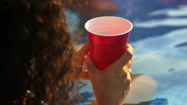 Woman with red cup during pool party