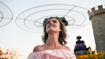 Girl on the background futuristic metal flowers in Dubai Miracle Garden Park.