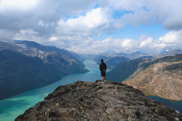 Jotunheimen National Park, Young male standing on a rock on Besseggen looking over  Gjende Fjord