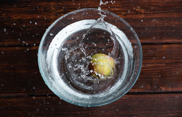 an Apple in water, an Apple in a spray of water in a glass transparent container, a wet Apple flying