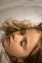 Obraz na płótnie Canvas Little blonde girl sleeping in her bed