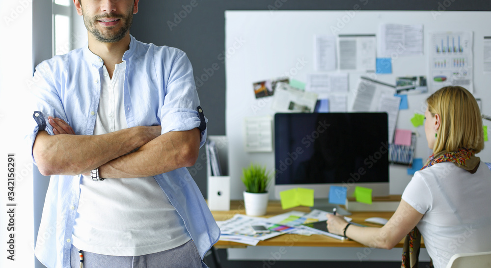 Poster portrait of young designer in front of laptop and computer while working. assistant using her mobile
