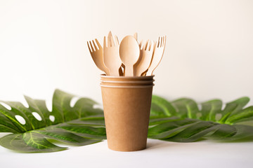 eco friendly disposable kitchenware utensils on white background. wooden forks and spoons in paper cup. ecology, zero waste concept. top view. flat lay.