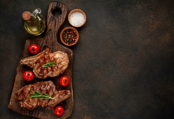 Obraz na płótnie Canvas two grilled beef steaks with spices on a stone background with copy space for your text