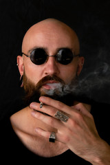 a young strange man alone walks with a cigarette through the ruins of a factory