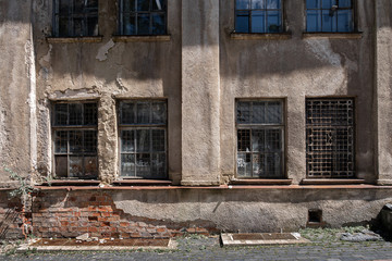 Damaged wall of an old building with windows