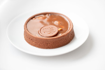 caramel tartlet on a plate on a white background