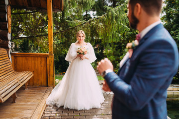 Beautiful wedding couple in a luxurious place for a photo shoot with flowers and architecture, the bride and groom in an embrace and love, the newlyweds are happy
