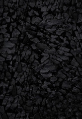 Natural black activated charcoal texture for backgrounds. Top view.