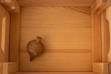 spinning top in a light wooden box