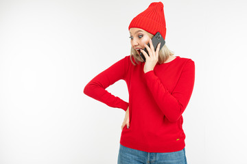 lovely girl in red chats on the phone on a white background with copy space