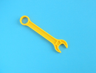 yellow plastic wrench on a blue background