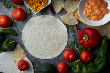 Still life of three fajitas or Mexican tacos with meat, pepper, tomato, spicy pepper and nachos. Mexican food concept.