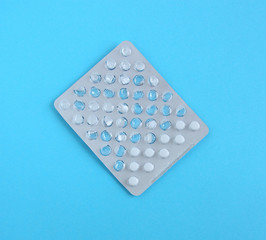 Empty pills package. Pharmaceutical blister pack. Pack of pills without tablets. Blue background