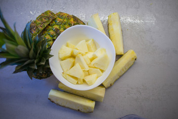 sliced fresh pineapple in a white plate on the kitchen