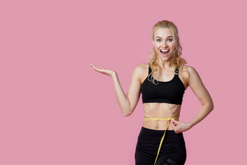 Fitness, workout, healthy lifestyle and diet concept - thin athletes women measure waist after...