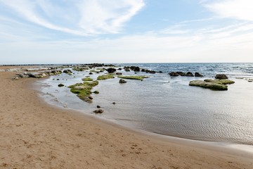 Sandy beach near Scala dei Turchi (Stair of the Turks) in Argigento, Sicily during the beautiful sunset with boulders and green moss