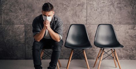 Young man with black mask in dark room pray for world and coronavirus quarantine