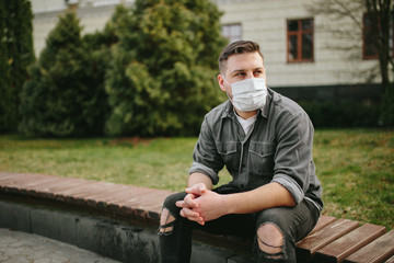 Young man with mask on face in city center at quarantine time