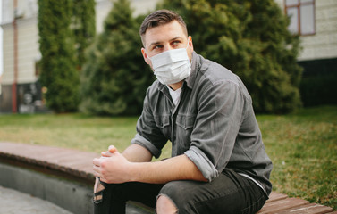 Young man with mask on face in city center at quarantine time