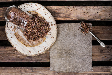 
buckwheat porridge buckwheat AND SPOON background wood wooden background dark background Buckwheat and sheet paper for notes and notes