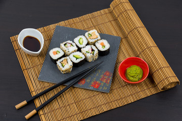 Tasty sushi roll on black stone plate 