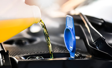 Pouring summer liquid or yellow car fluid for washing car screen