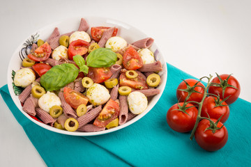 Pasta salad with mozzarella and cherry tomatoes, basil