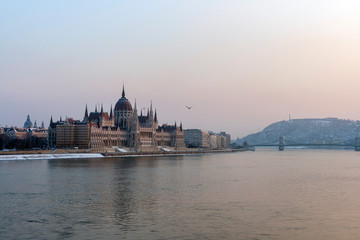 Obraz premium The river Danube on a cold winter day with the Hungarian Parliament building in the background