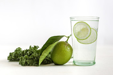 A glass of warm clear water with slices of lime
