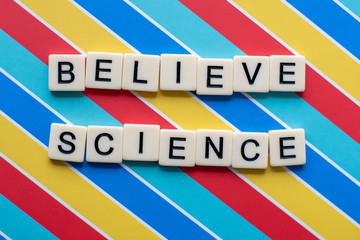 Believe Science letter tiles on colorful background