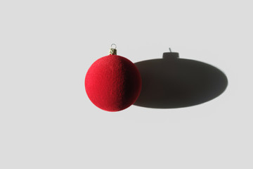 Red Christmas bauble with shadow on white background