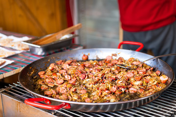 Closeup of traditional Polish sauerkraut bigos food dish with sausage meat, onion and cabbage on frying pan at Warsaw Poland christmas market