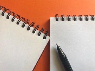 notepad and pen on colored background