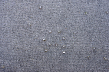 Full frame sectional close-up view of a gray pin board with translucent pins randomly placed