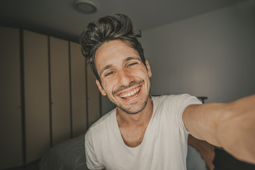 Happy handsome man takes a selfie at home during quarantine.