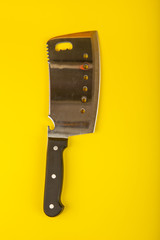 Butcher knife with wooden handle on yellow background