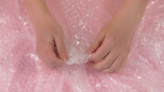 Women hand clench and slam anti-stress bubble wrap