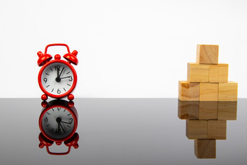 Red alarm clock and wooden cube block with leadership concept