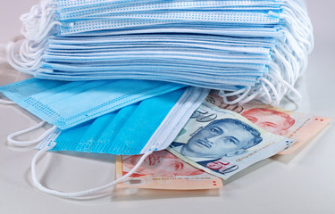 Face masks, the new currency in Singapore and the world. Corona Cov19 crisis makes mouth mask to most wanted equipment. Prices rising high. Box of face mask with Singapore dollar on white background. 