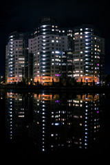 apartment building by the river in a night city