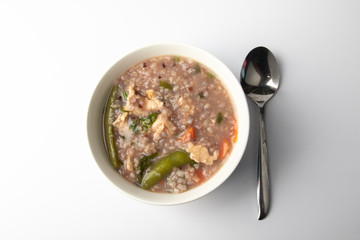 Delicious homemade brown rice porridge with few slice chicken, carrot and vegetable isolated on white background.  