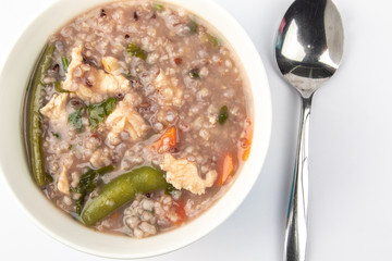 Delicious homemade brown rice porridge with few slice chicken, carrot and vegetable isolated on white background.  