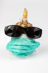 Pineapple wearing surgical mask and sunglasses isolated on white background - Global impact of COVID-19 concept