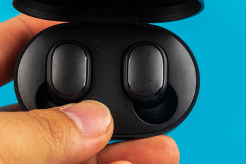 Wireless Bluetooth headphones on reflection surface.