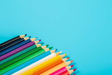 portrait of set of colorful pencils on blue background with copy space