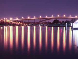 Night Long exposure of Gladesville Bridge in Sydney Australia illuminated by the bright lights and smooth harbour waters light up 