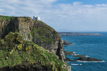 Fototapeta na wymiar Dramatic scenery of the coast consisting of cliffs and a white house