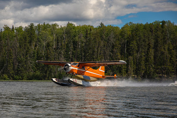 Seaplane taking off with canoe tied on.  Wilderness travel and solitude 