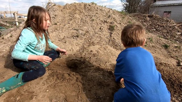 Cute Kids Playing Dump Of Soil At The Backyard Of Their House In Flat Rock Michigan During A Sunny Morning - Close Up Shot